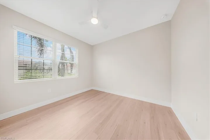Empty room with light wood-style floors and a ceiling fan