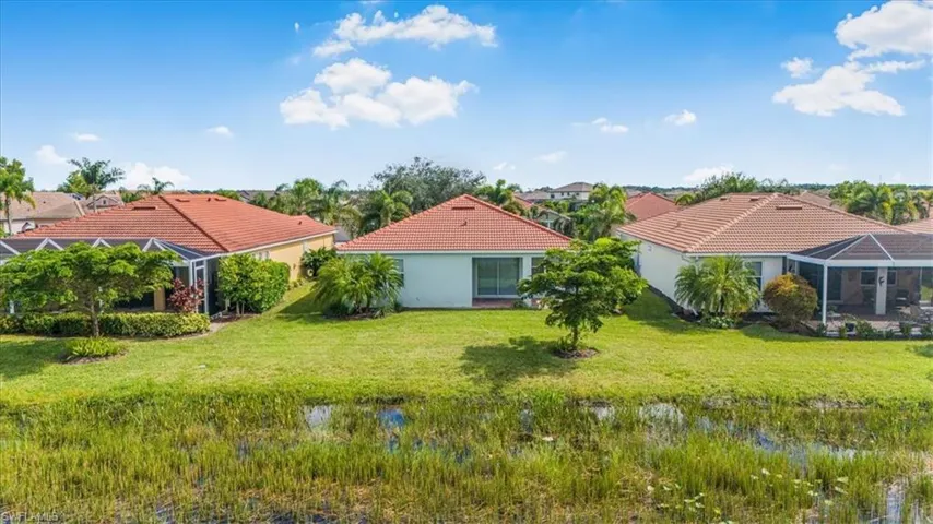 View of green lawn with a lanai and a sunroom