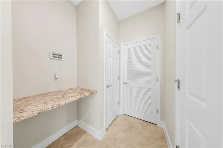 Entryway with tile patterned floors and built in desk