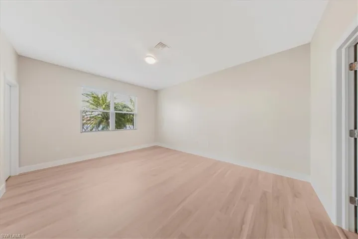 Unfurnished bedroom with light wood-style floors and baseboards