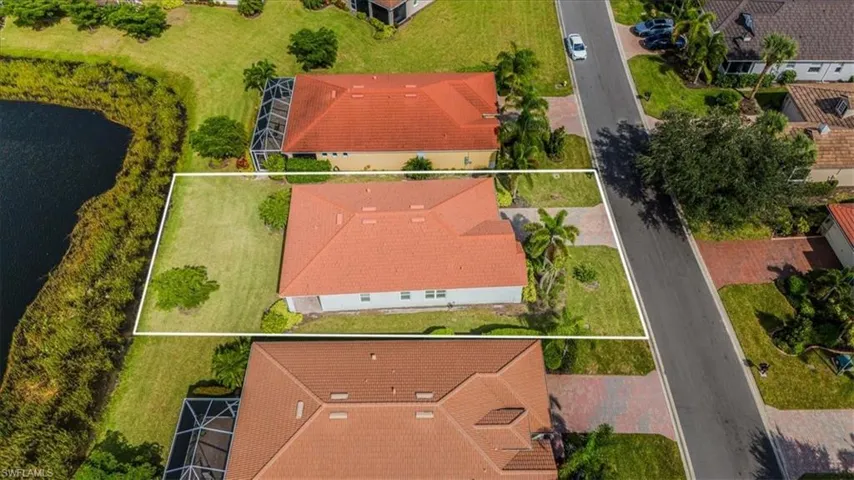 Aerial view of residential area featuring property parcel outlined and a nearby body of water