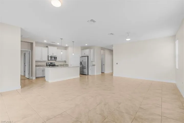 Unfurnished living room featuring recessed lighting and light tile patterned floors