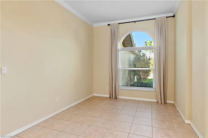 Dining Room with crown molding and light tile patterned flooring