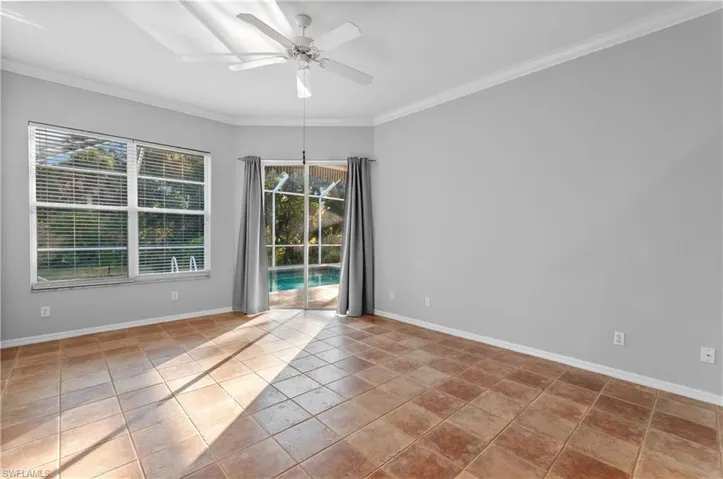 Primary bedroom with direct access to pool, ornamental molding and a ceiling fan