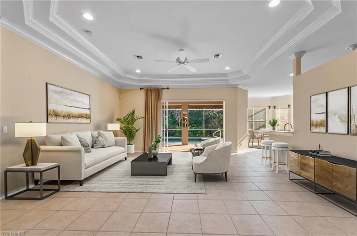 Virtually staged great room  area with crown molding, light tile, ceiling fan, and recessed lighting