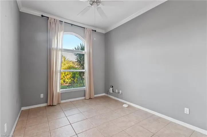 2nd Bedroom with ceiling fan, ornamental molding, and light tile patterned floors