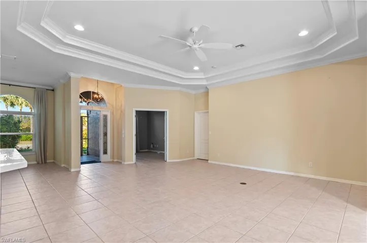 Great room with crown molding, a tray ceiling, light tile patterned floors, and recessed lighting