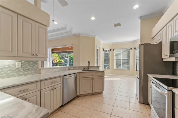 Kitchen featuring appliances with stainless steel finishes, crown molding, tasteful backsplash, a ceiling fan, and recessed lighting