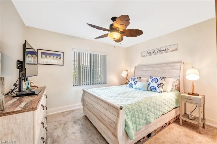 Bedroom with light carpet, baseboards, and ceiling fan