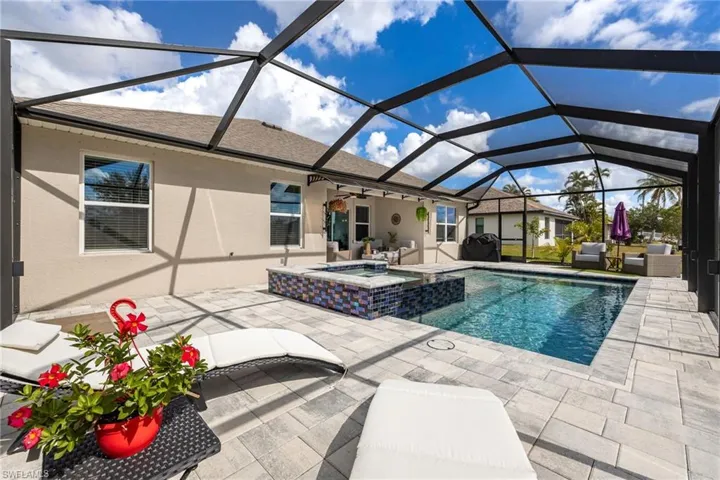 View of swimming pool featuring a sunroom, a patio, a pool with connected hot tub, and a lanai