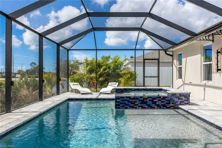 Outdoor pool with a jacuzzi, a sunroom, glass enclosure, and a patio