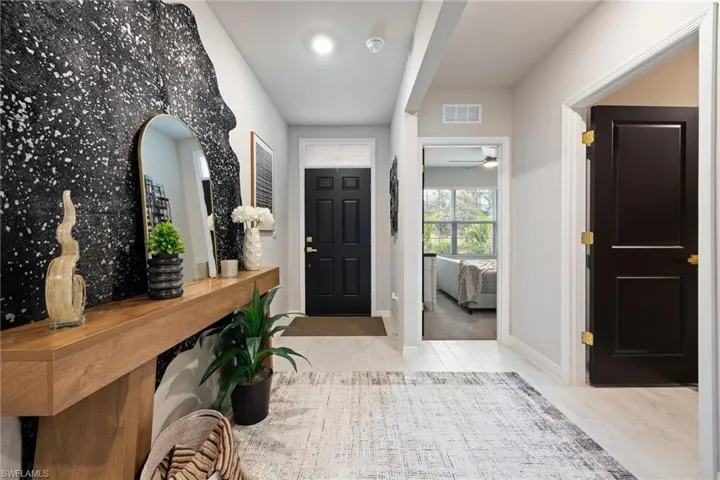 Foyer entrance with ceiling fan and light wood-type flooring