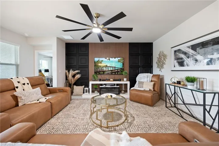 Living area with an accent wall and a ceiling fan