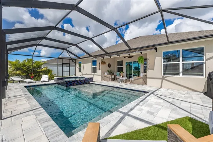 View of pool featuring a sunroom, ceiling fan, a lanai, and a pool with connected hot tub