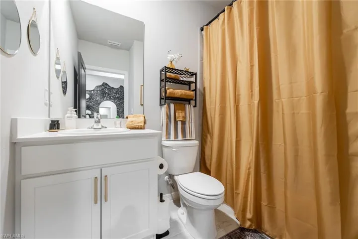 Full bathroom featuring a shower with shower curtain, vanity, and tile patterned floors