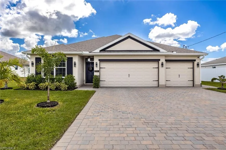 Single story home featuring a front lawn, stucco siding, decorative driveway, a garage, and a shingled roof