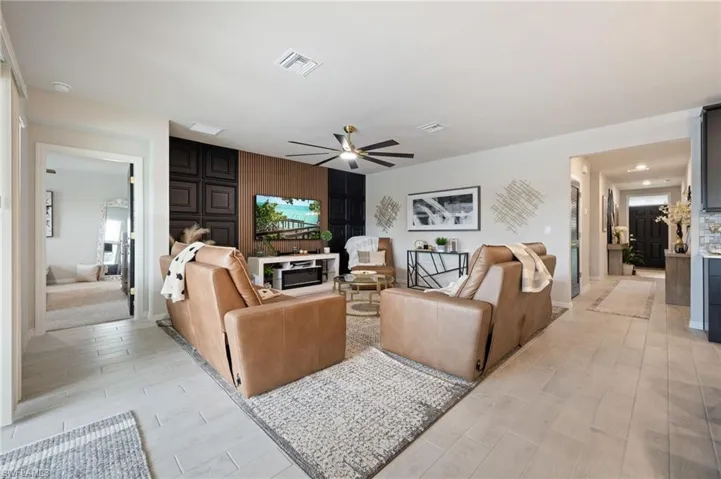 Living area with ceiling fan and light wood-style flooring