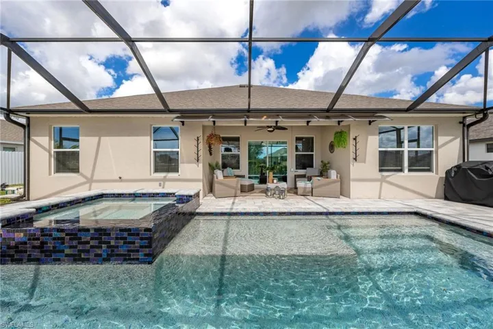 Back of property with a sunroom, a ceiling fan, glass enclosure, and stucco siding