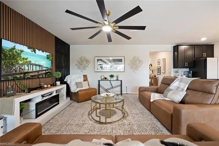 Living area with a ceiling fan and baseboards