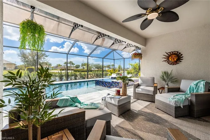 View of patio with a sunroom, an outdoor pool, glass enclosure, and ceiling fan