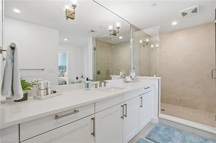 Ensuite bathroom with a stall shower, vanity, and recessed lighting - Virtually Edited Image