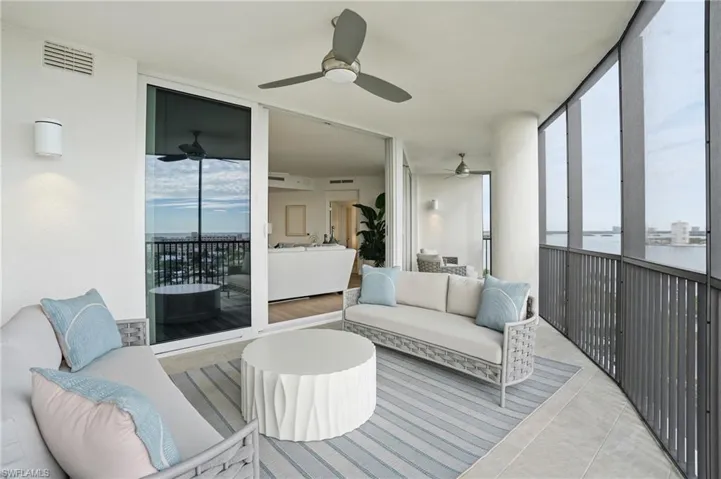 Sunroom featuring a wall of windows, an outdoor hangout area, plenty of natural light, a ceiling fan, and tile patterned floors - Virtually Edited Image