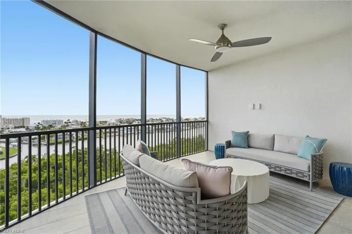 Sunroom with a water view, outdoor lounge area, and a ceiling fan - Virtually Edited Image