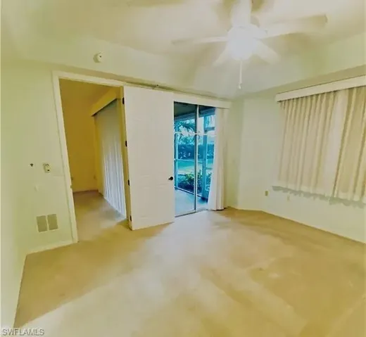 Empty room featuring a ceiling fan and light colored carpet