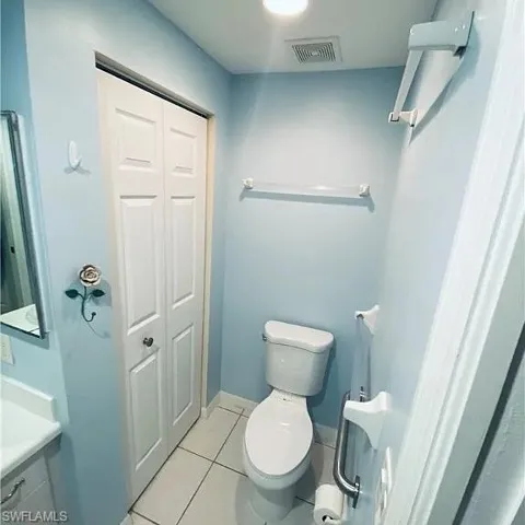 Bathroom with a closet, light tile patterned floors, and vanity