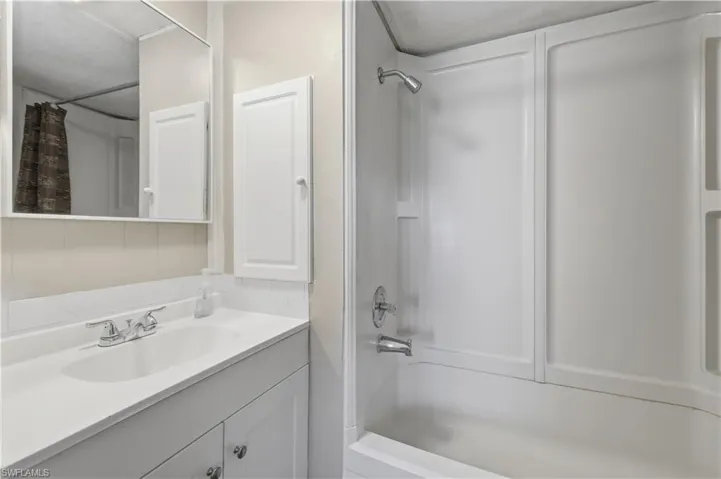 Bathroom with vanity and shower / bath combination with curtain
