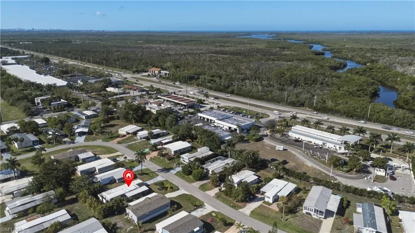 Aerial view of property's location featuring a forest and nearby suburban area