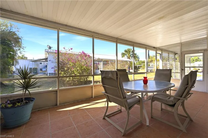 Sunroom / solarium with tile patterned floors and wooden ceiling