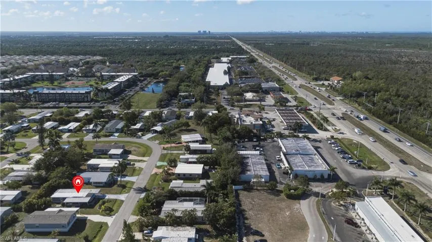 Aerial view of property and surrounding area featuring a large body of water and nearby suburban area