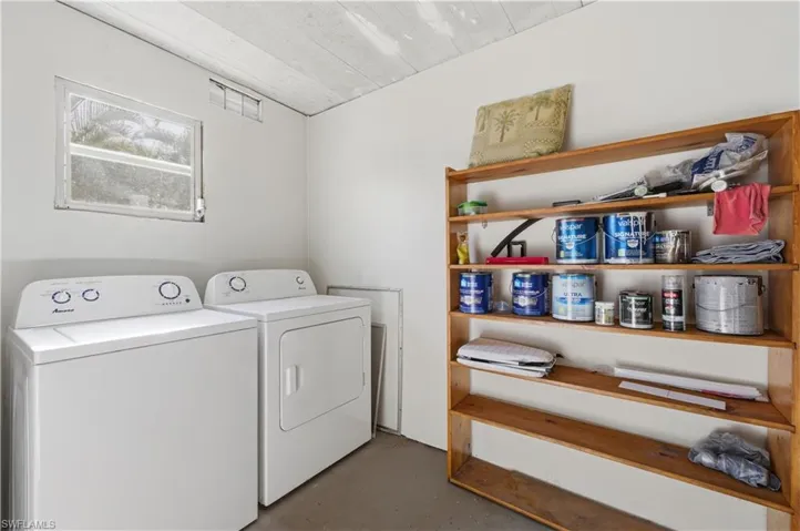 Laundry room featuring finished concrete floors and washer and dryer