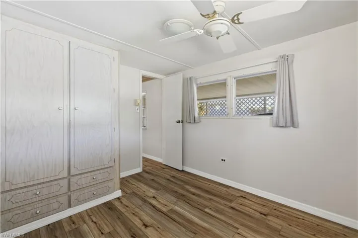 Unfurnished bedroom featuring dark wood-style flooring and ceiling fan