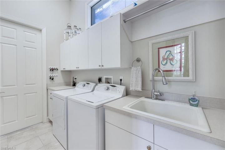 Laundry with storage, sink AND transom windows for additional lighting.