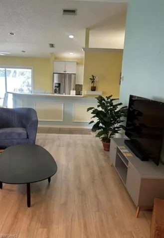 Living area with light  flooring, and recessed lighting
