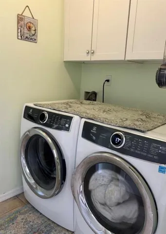 Laundry area featuring cabinet space and full size washer and dryer