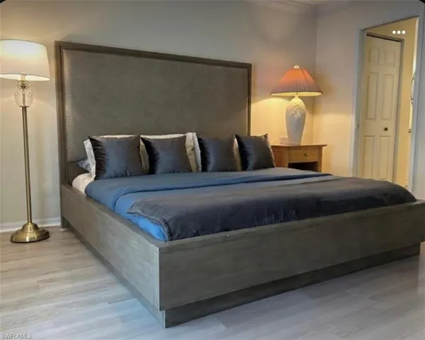 Bedroom featuring wood finished floors and ornamental molding