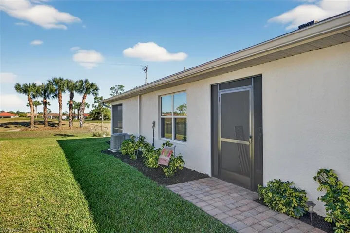Screened doorway to property with a yard and stucco siding