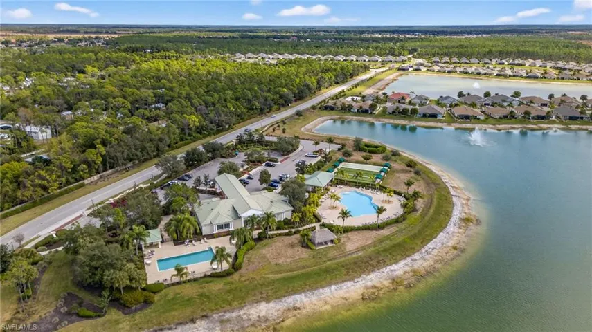 Aerial perspective of suburban area with a pool and a nearby body of water