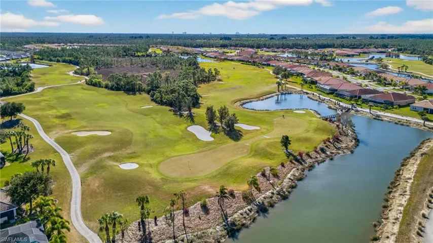 Aerial perspective of suburban area featuring a golf course and a large body of water