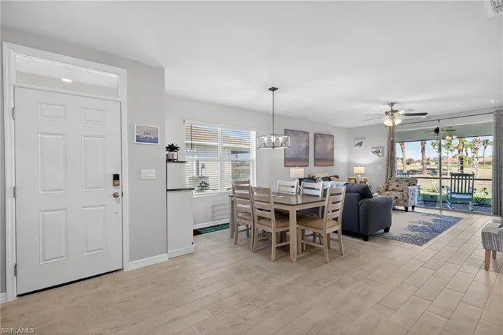 Dining area featuring ceiling fan, tile floors, and hanging lights