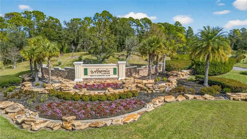 Community / neighborhood sign with a lawn and view of scattered trees