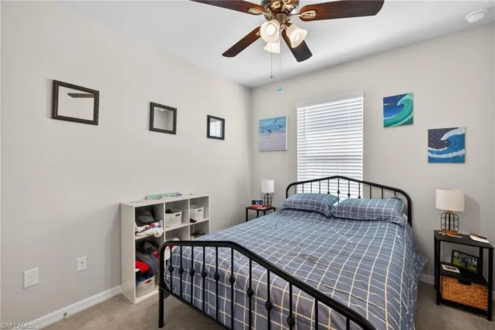 Carpeted bedroom with baseboards and ceiling fan