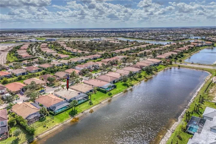 Aerial perspective of suburban area featuring a nearby body of water