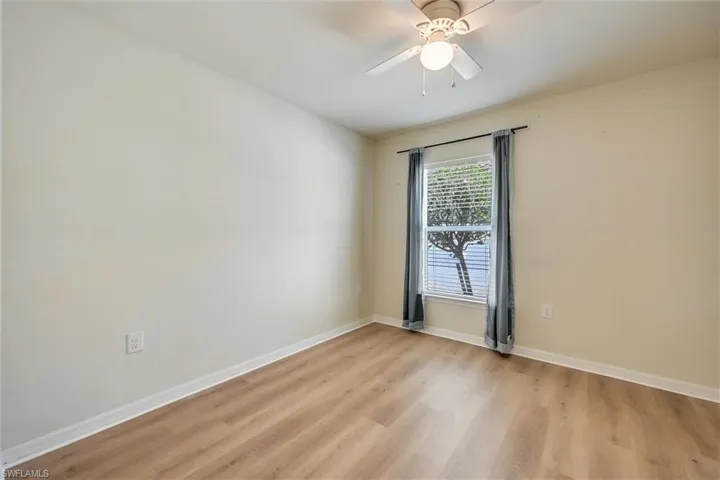 Empty room featuring light wood-type flooring and a ceiling fan