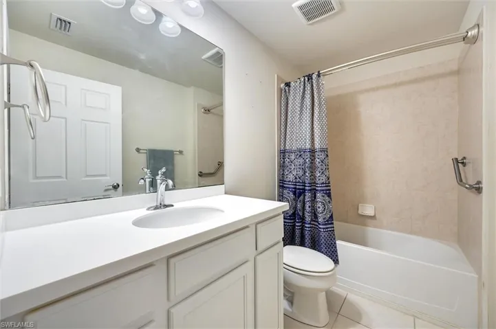 Full bathroom featuring vanity, light tile patterned floors, and shower / bath combination with curtain