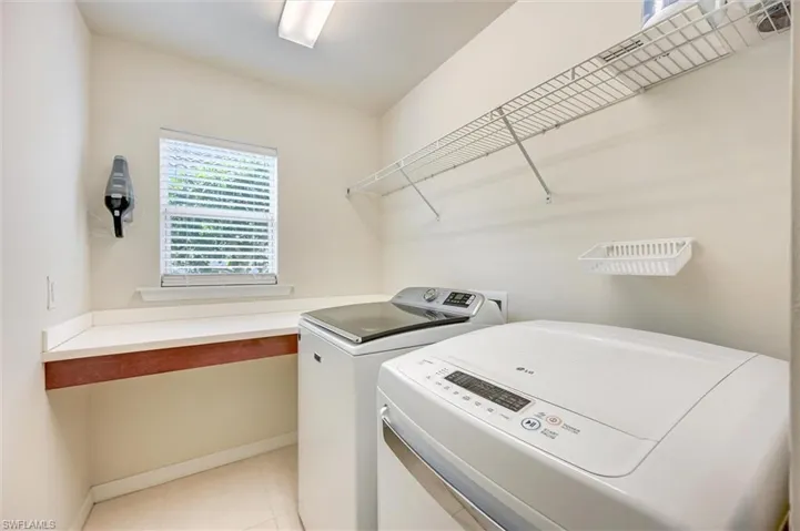Laundry room featuring independent washer and dryer and light tile patterned flooring