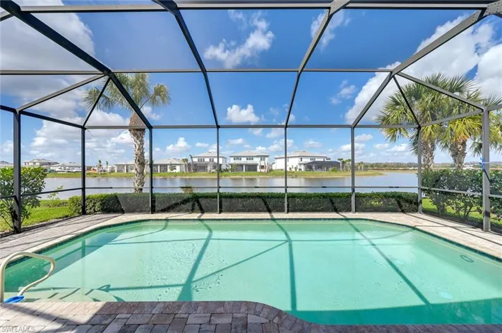 Swimming pool with a sunroom, a residential view, a water view, and a lanai